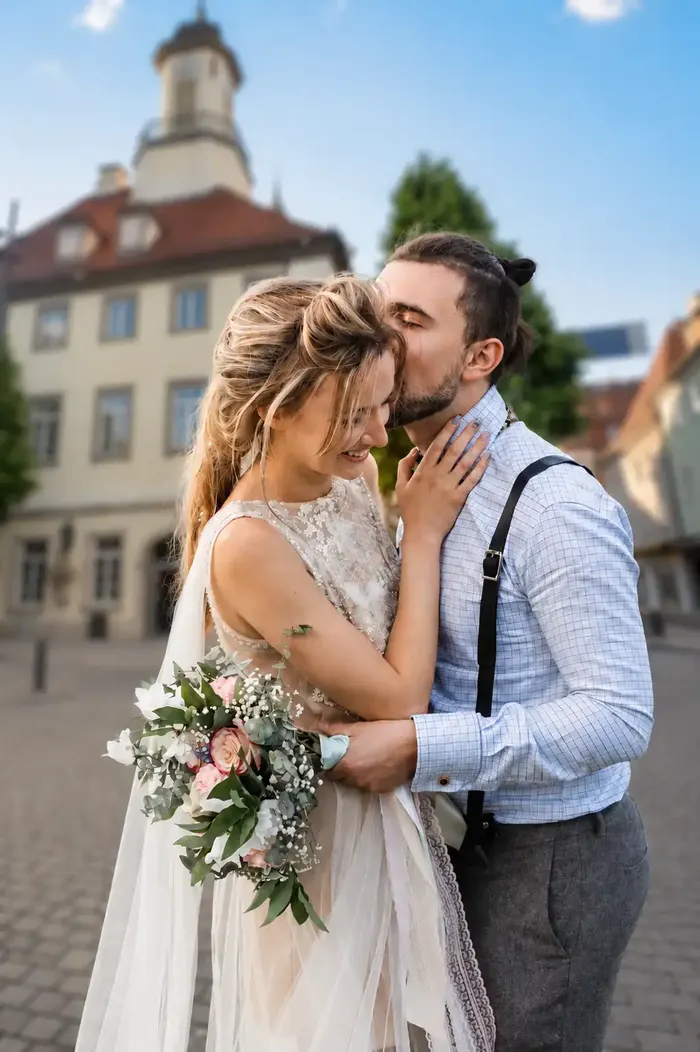 Brautpaar umarmt sich innig vor historischer Altstadtkulisse
